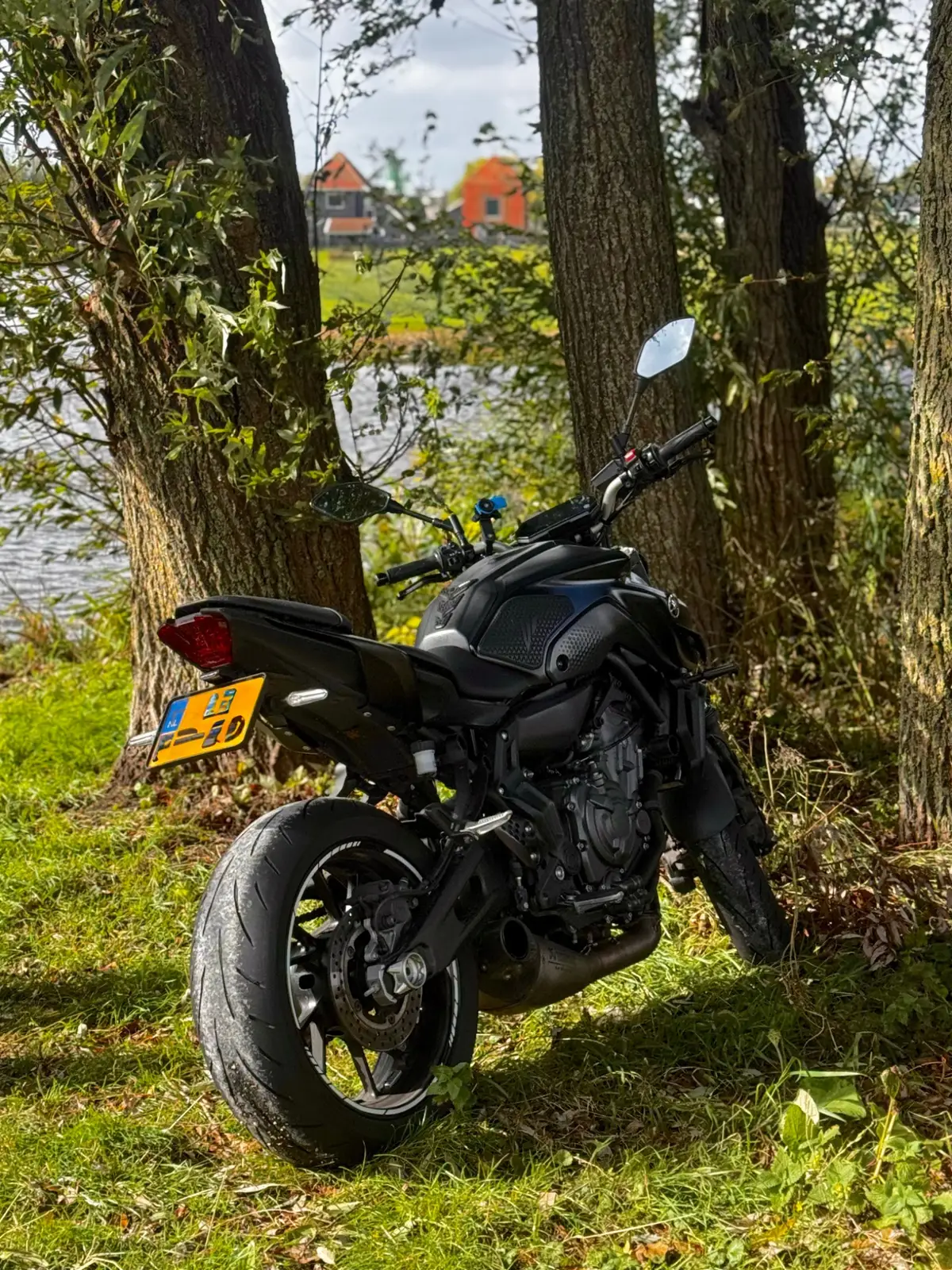 Black Yamaha MT-07 parked near trees by the water, useful for target fixation awareness