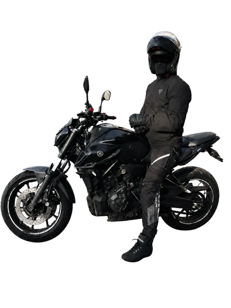 Motorcyclist wearing black riding gear seated on a black Yamaha MT-07 motorcycle