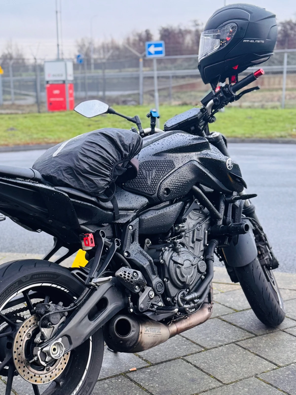 Black Yamaha MT-07 parked on a wet roadside in rainy conditions