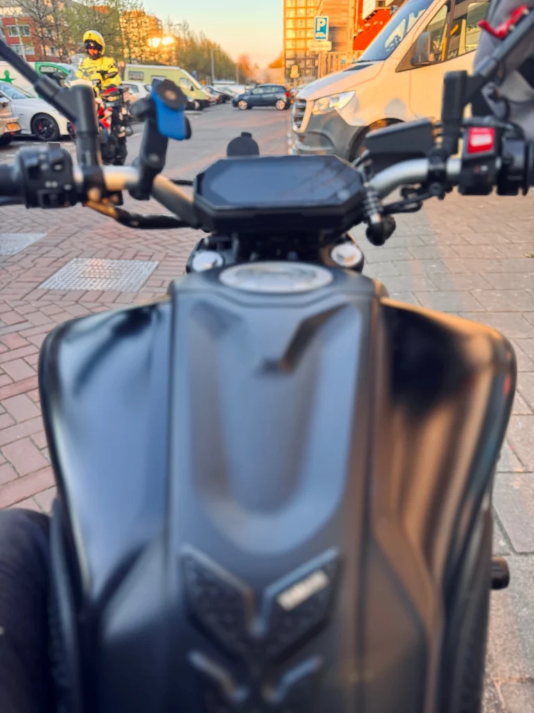 Rider POV on a Yamaha MT-07 in city traffic, showing awareness of surrounding vehicles