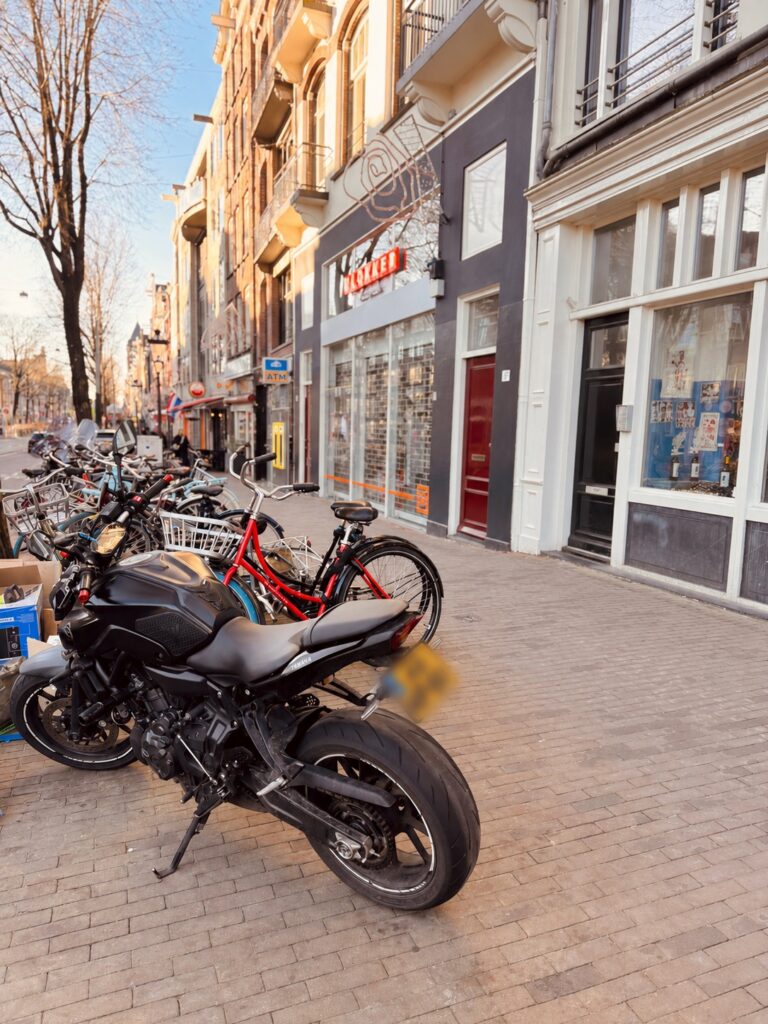 Motorcycle parked in city street showing road surface hazards and traffic awareness in urban environment