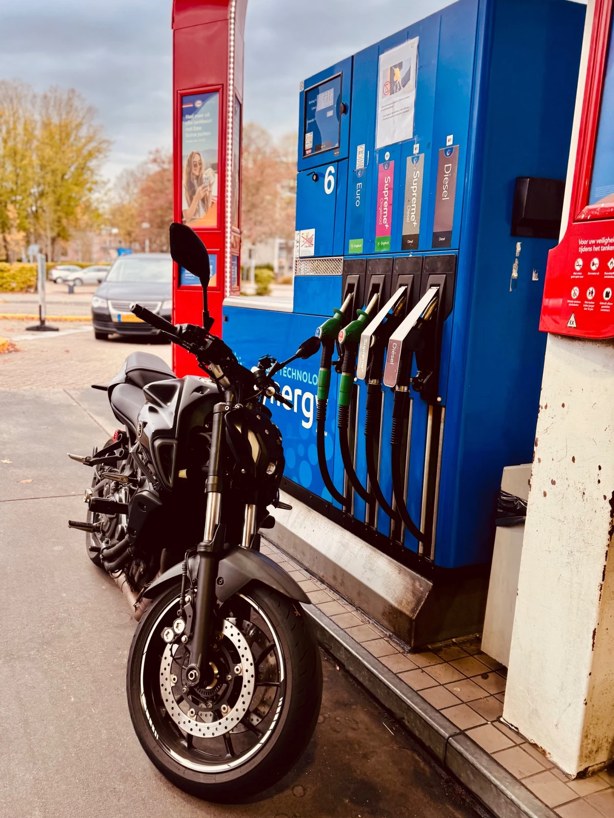 Black Yamaha MT-07 parked beside a fuel pump during a motorcycle fuel stop