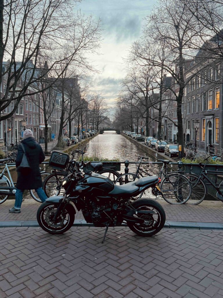 Urban street with pedestrian walking showing where motorcyclists should slow down and scan for hazards