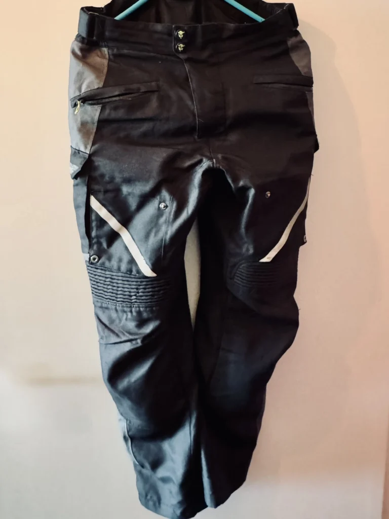 MotoTech black motorcycle riding pants hanging on a wall