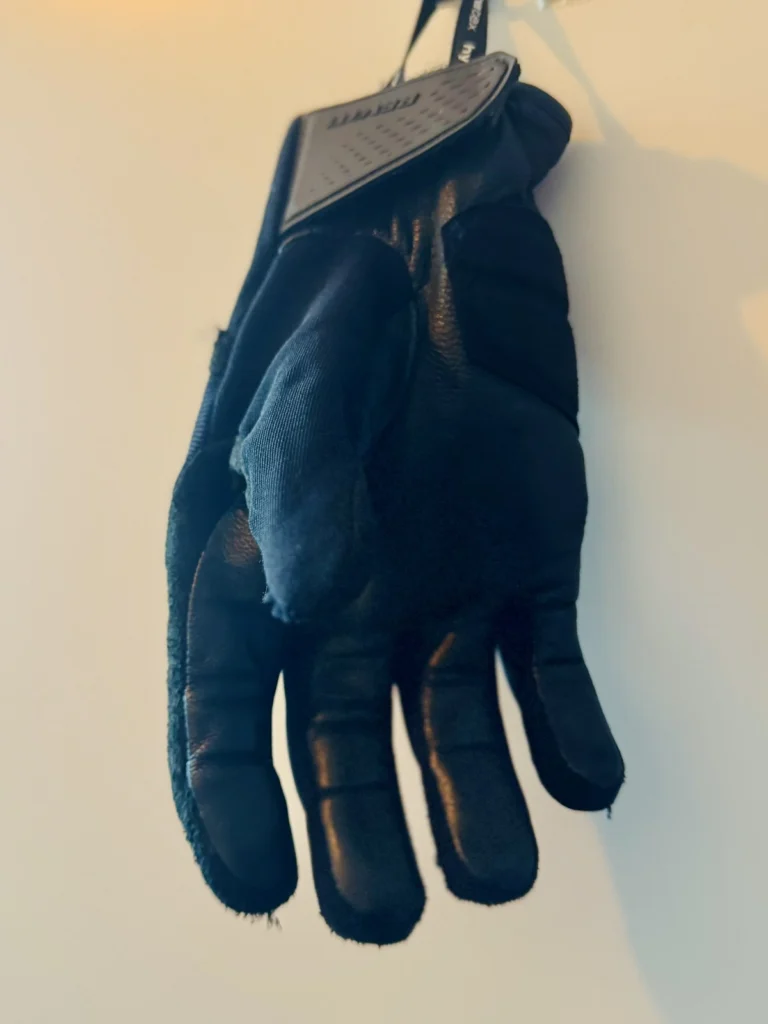 Single REV’IT Mosca 2 H2O motorcycle glove hanging on a wall
