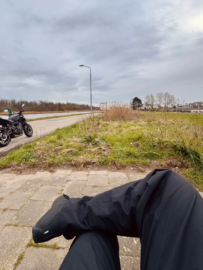 Rider wearing REV’IT Acid H2O rain pants during a roadside break