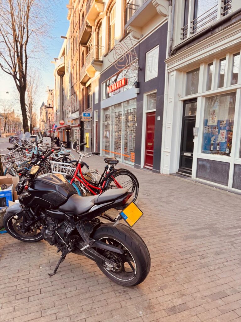 Yamaha MT-07 parked on a busy city sidewalk with bicycles nearby