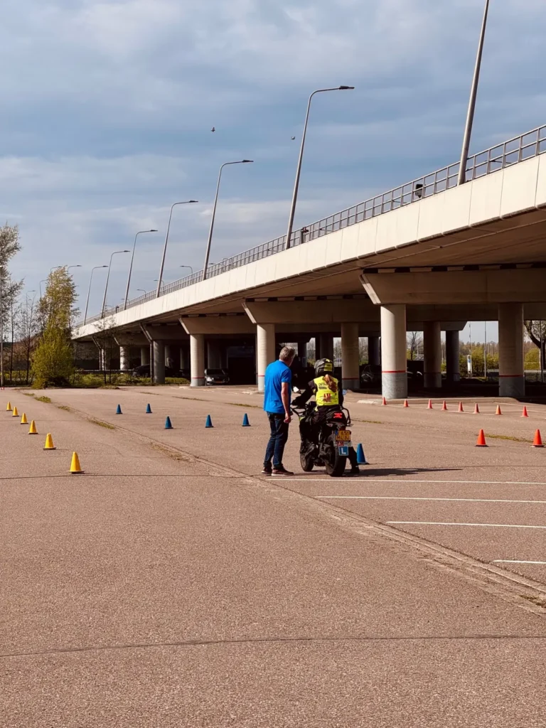 Motorcycle instructor coaching a rider in a cone practice area