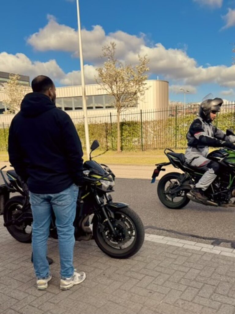 Motorcycle instructor observing a student rider during practical road training