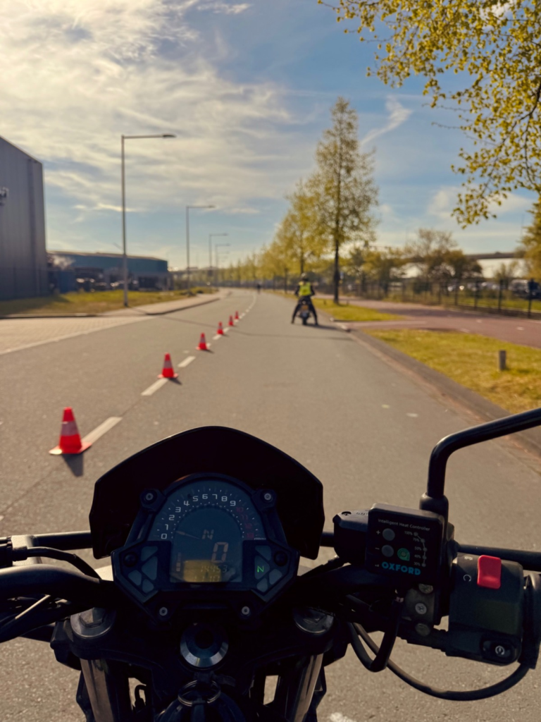 Rider’s view of a motorcycle training exercise with traffic cones on a closed road
