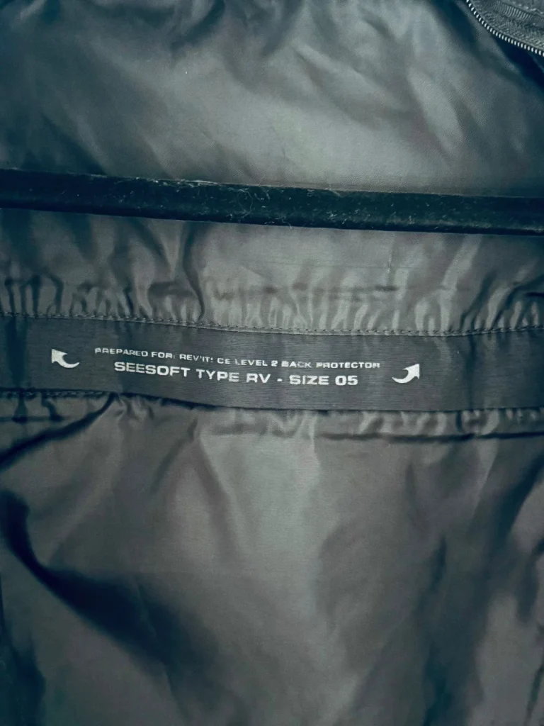 Label inside motorcycle jacket showing back protector compatibility and size information