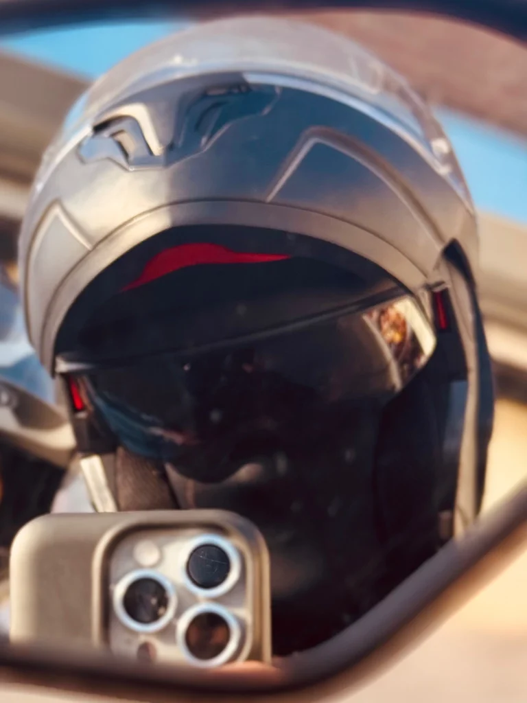 Close-up mirror selfie of rider wearing modular helmet