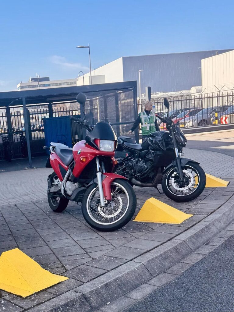 Motorcycles parked near yellow speed bumps showing uneven surfaces riders should approach smoothly