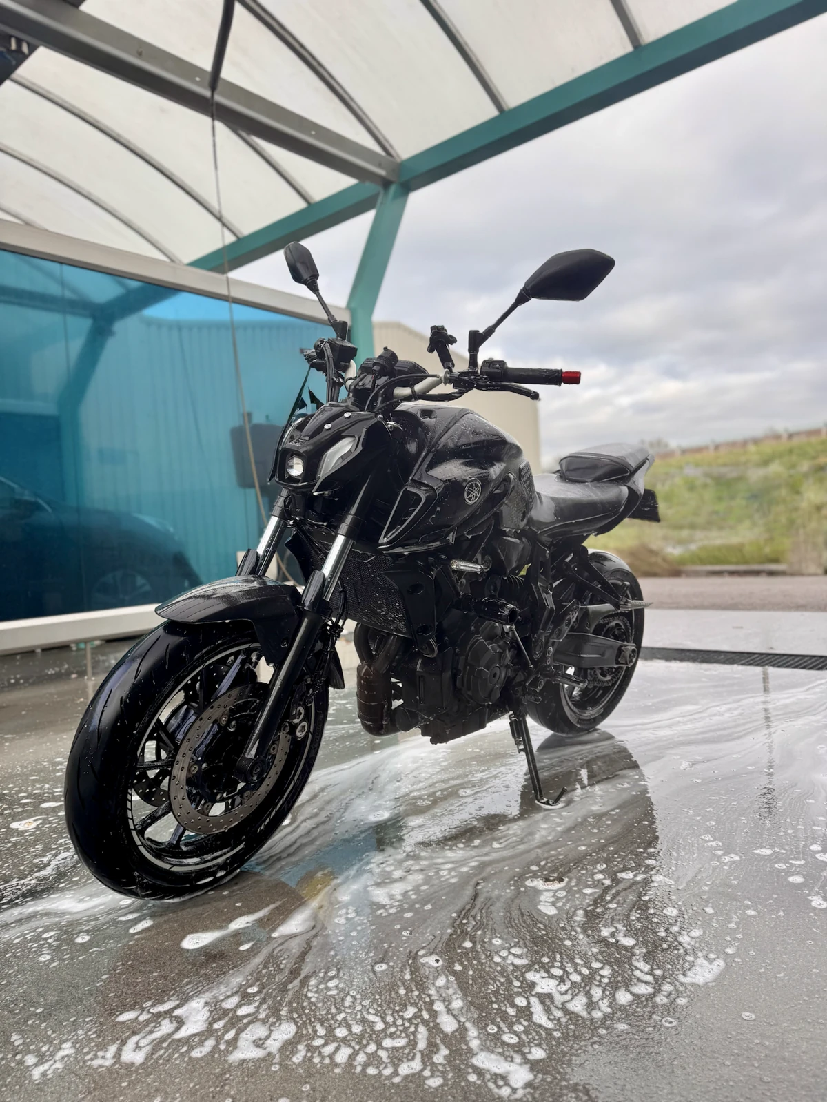 Yamaha MT-07 on a wet wash bay floor showing how slippery surfaces can reduce traction