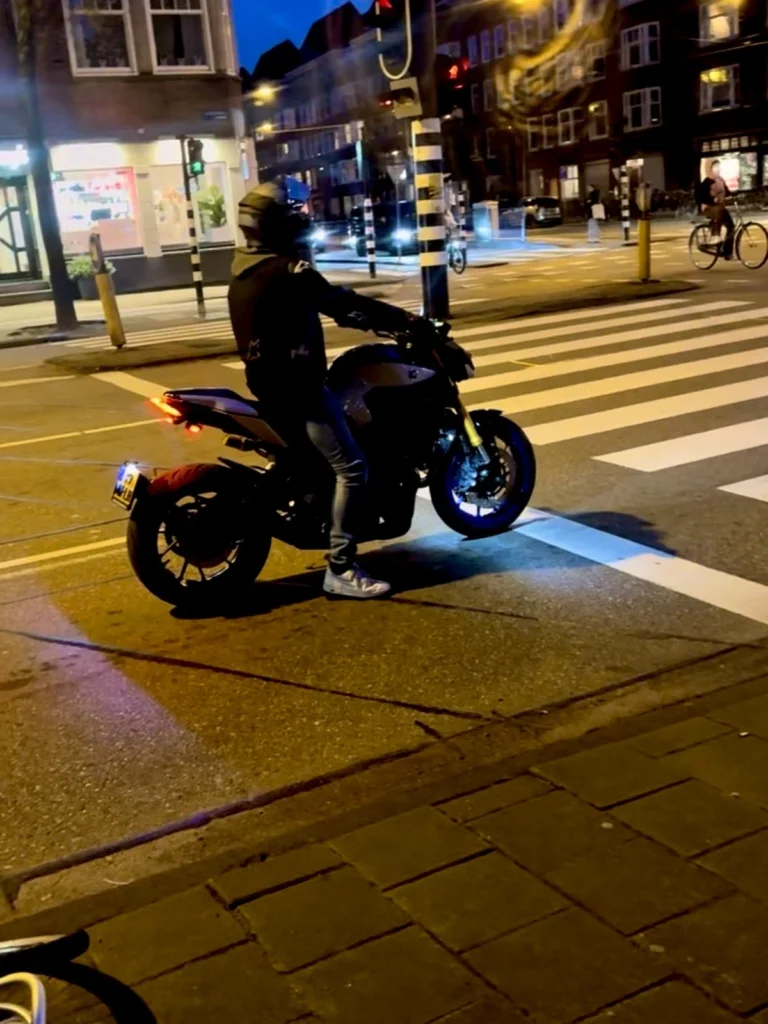 Motorcyclists at a junction with road painting for pedestrians crossing