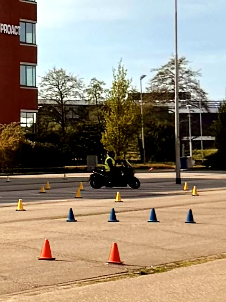 Beginner motorcycle rider practicing slow balance turns through cones during training