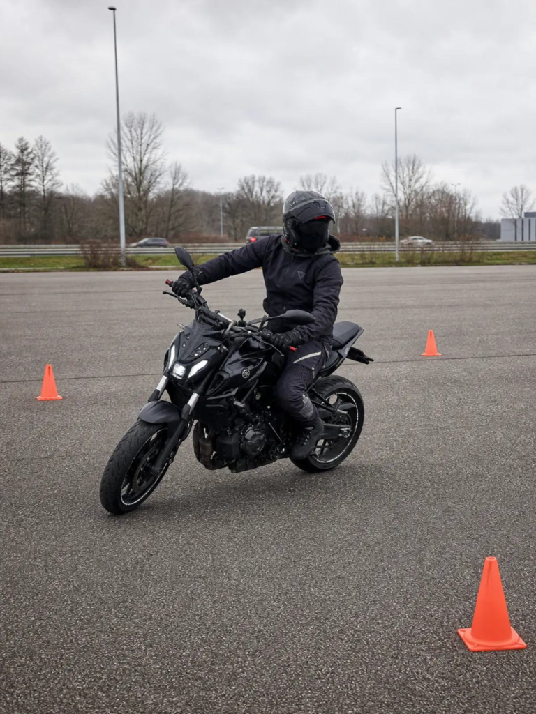 Rider practicing a slow motorcycle U-turn in a safe open area