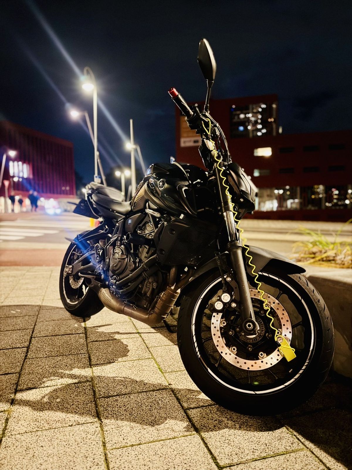Yamaha mt07 parked under streetlights at night beside an urban road