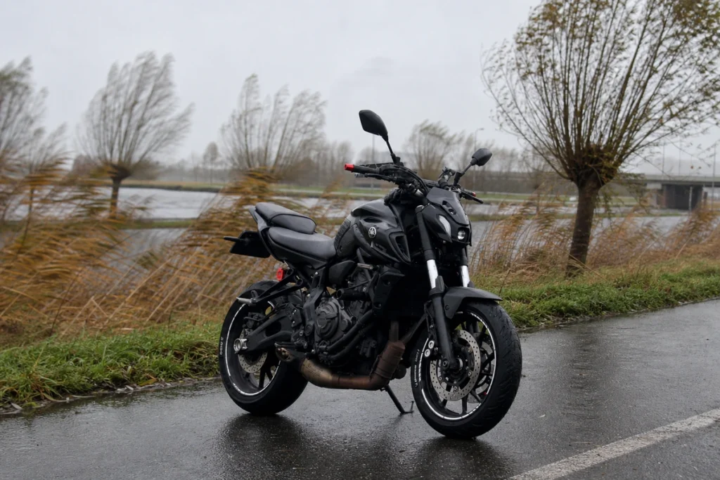 Yamaha mt-07 parked beside a wet road with windswept grass and trees nearby