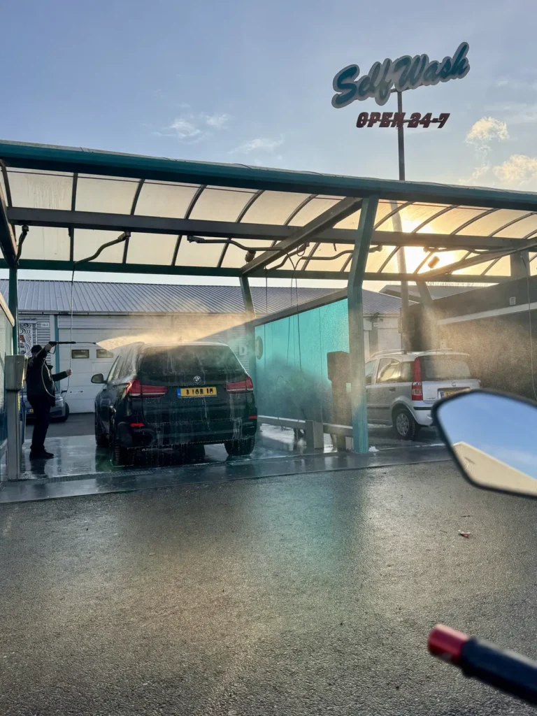 Water sprayed on to motorcycle rider from car ahead
