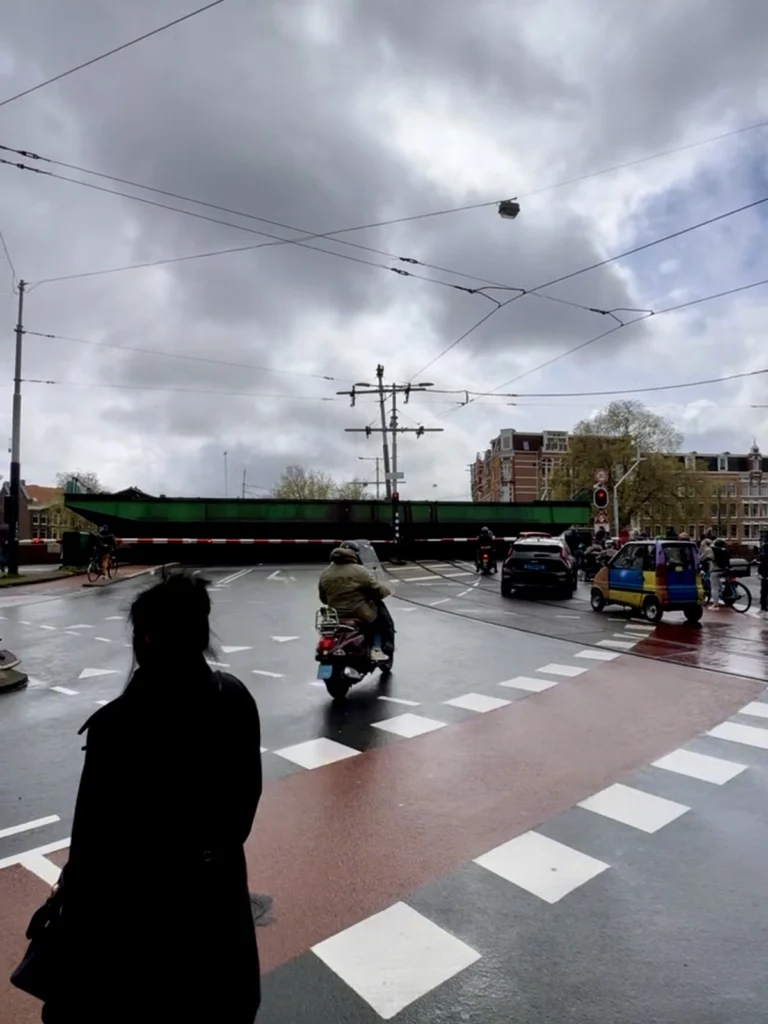Wet tram tracks on an Amsterdam road viewed by a motorcyclist